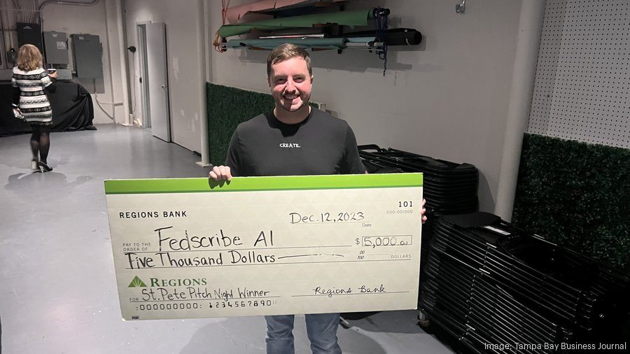Johnny Saye holding the $5,000 St. Pete Pitch Night check, Dec 12 2023